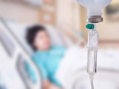 Medical drip with patient in the hospital blurred background