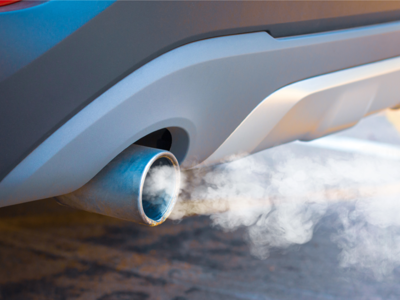 Car emissions appearing from close-up of exhaust