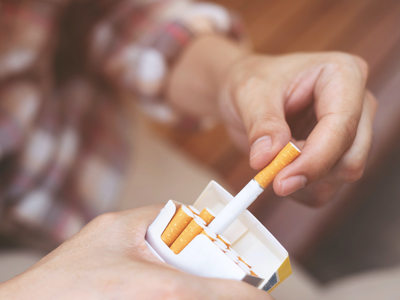 Close-Up Of Person Holding Cigarette Pack - stock photo