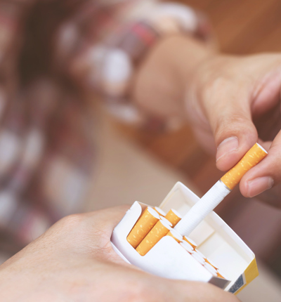 Close-Up Of Person Holding Cigarette Pack - stock photo