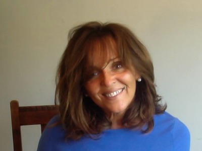 Smiling woman with brown hair and blue dress