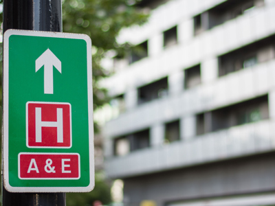 A roadsign pointing to a hospital