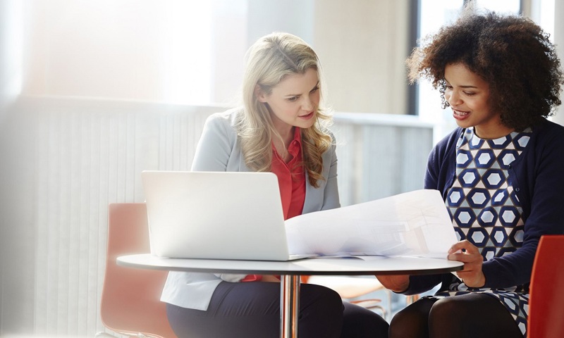 Two Professional Women Looking A Documents
