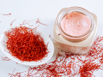 Saffron and cosmetic cream on a black background. Cream with saffron extracts - stock photo