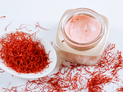 Saffron and cosmetic cream on a black background. Cream with saffron extracts - stock photo