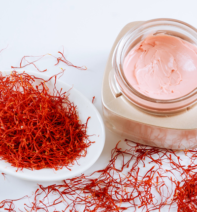 Saffron and cosmetic cream on a black background. Cream with saffron extracts - stock photo