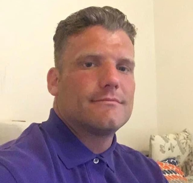 Sheldon Jeans, a man with light brown hair wearing a blue polo shirt