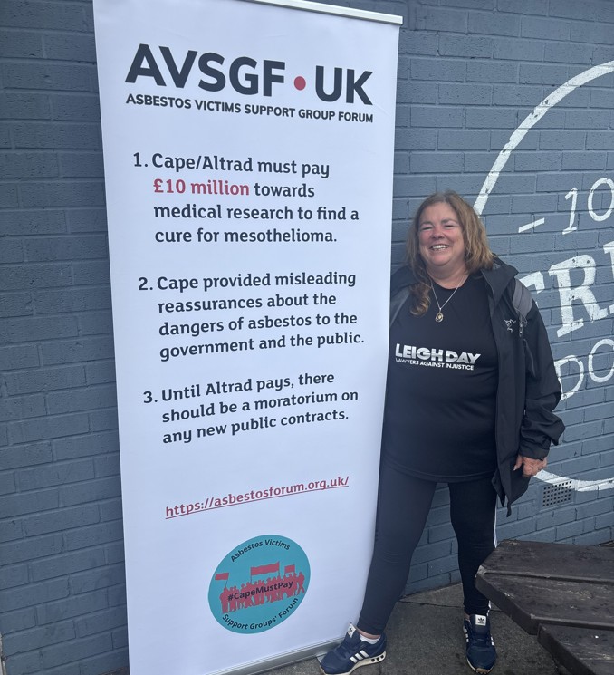 Joanne Candlish stood next to a banner for Asbestos Victims Support Group Forum
