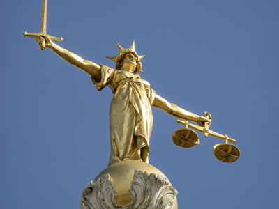The gold bronze Lady Justice statue with sword and scales above the Central Criminal Court, Old Bailey, London
