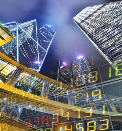 skyscrapers at night with stock market figures superposed