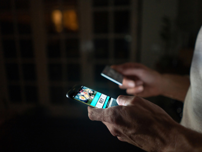 Man betting online at home on his cell phone