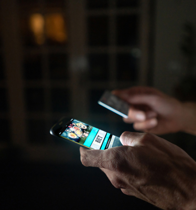 Man betting online at home on his cell phone