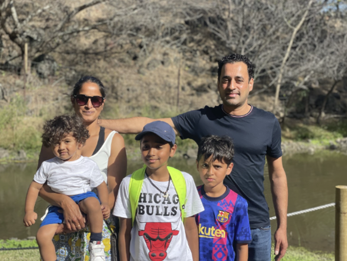 A family of a mum, dad and three children in front of a river