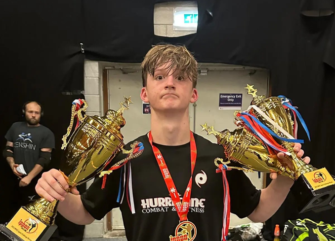 Alex eastwood, a boy holding three trophies