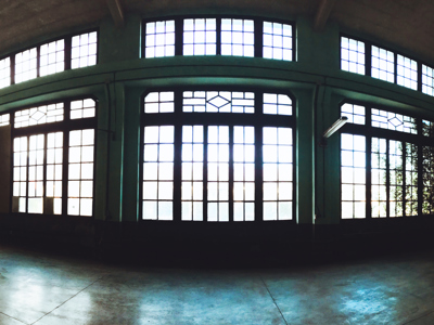 A silhouette of a generic empty industrial warehouse with large black edged glass windows