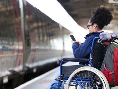 Young Female Wheelchair User At Train Station