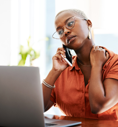 Woman with glasses on her mobile phone, hand on neck