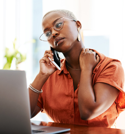 Woman with glasses on her mobile phone, hand on neck