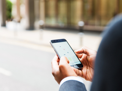 Close up of businessman using taxi app - stock photo