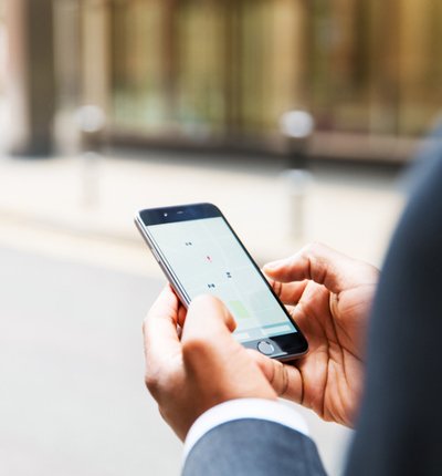 Close up of businessman using taxi app - stock photo