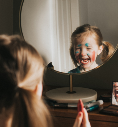 Child looking in mirror in facepaint