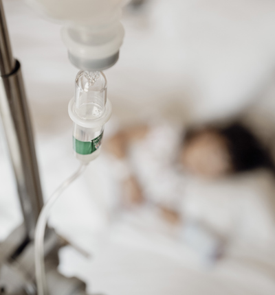 Close-Up View of Saline Drip Hanging on Metal Hook in Hospital Setting