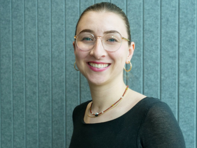 Maja Berger, a woman wearing glasses and a necklace smiling