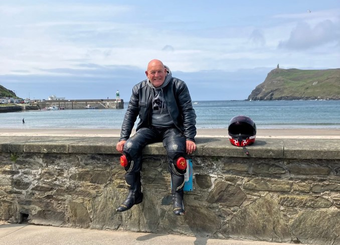 Tom Frith, a man sitting on a wall by the sea