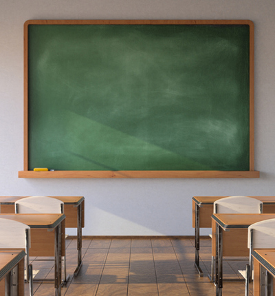 An empty classroom with a blank blackboard, chairs and tables
