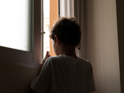 Child looking through gap in door