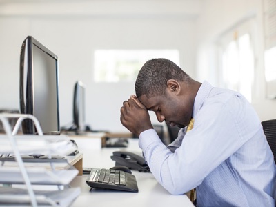 Stressed Black Man At Desk