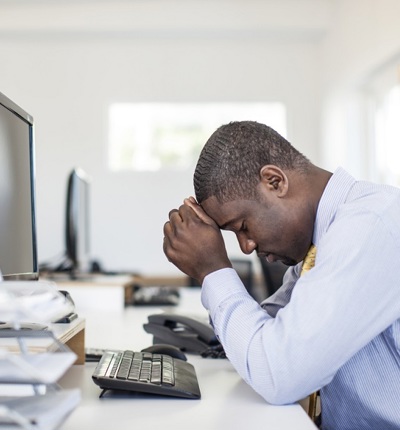 Stressed Black Man At Desk