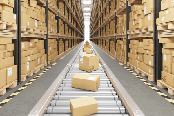 Brown cardboard boxes on a silver conveyor belt next to shelves of brown cardboard boxes