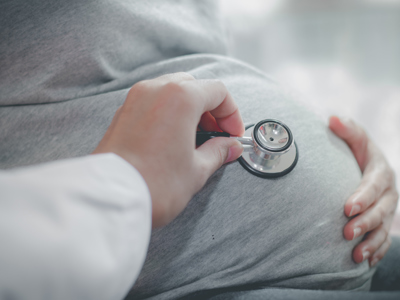 Cropped Hand Of Doctor Examining Pregnant Woman Belly With Stethoscope