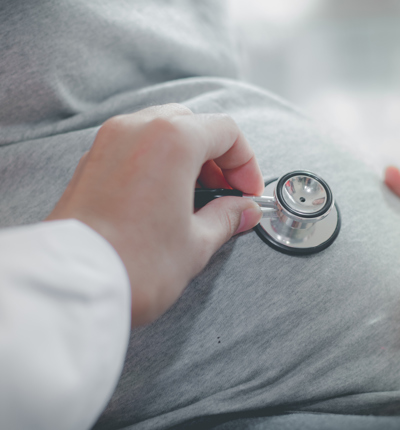 Cropped Hand Of Doctor Examining Pregnant Woman Belly With Stethoscope