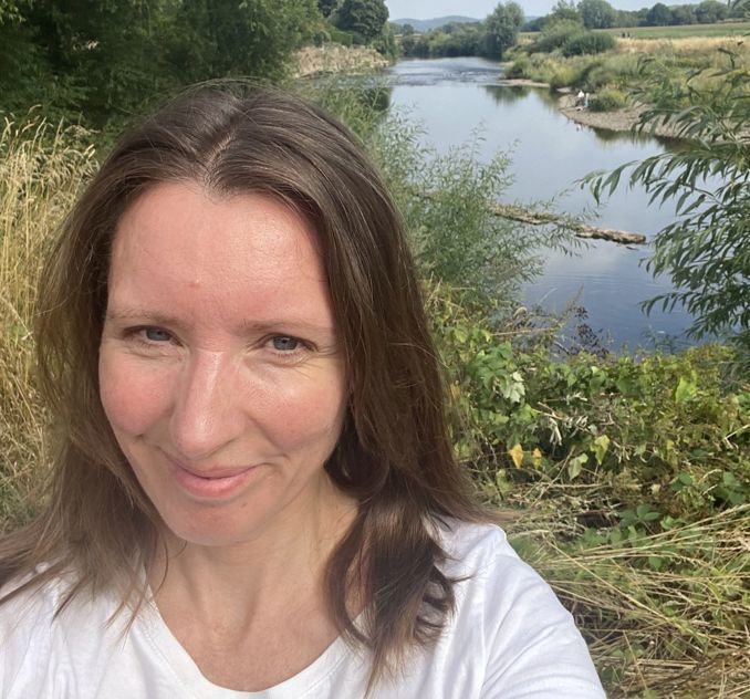 A woman standing in front of the river Wye