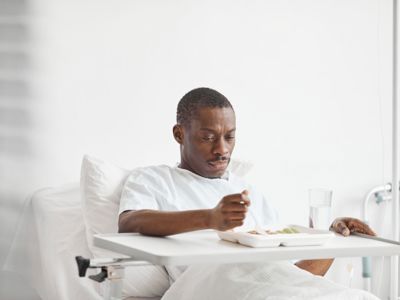 Man in a hospital bed with a tray of food