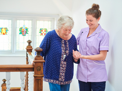 Home carer helping get up the stairs