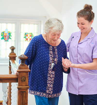 Home carer helping get up the stairs