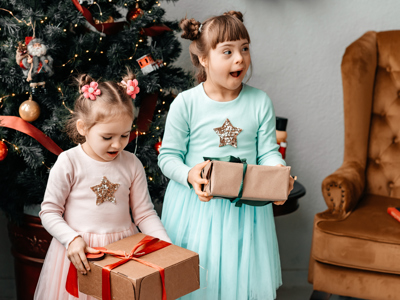 Children with gifts in their hands near the tree.