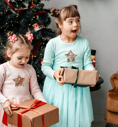 Children with gifts in their hands near the tree.