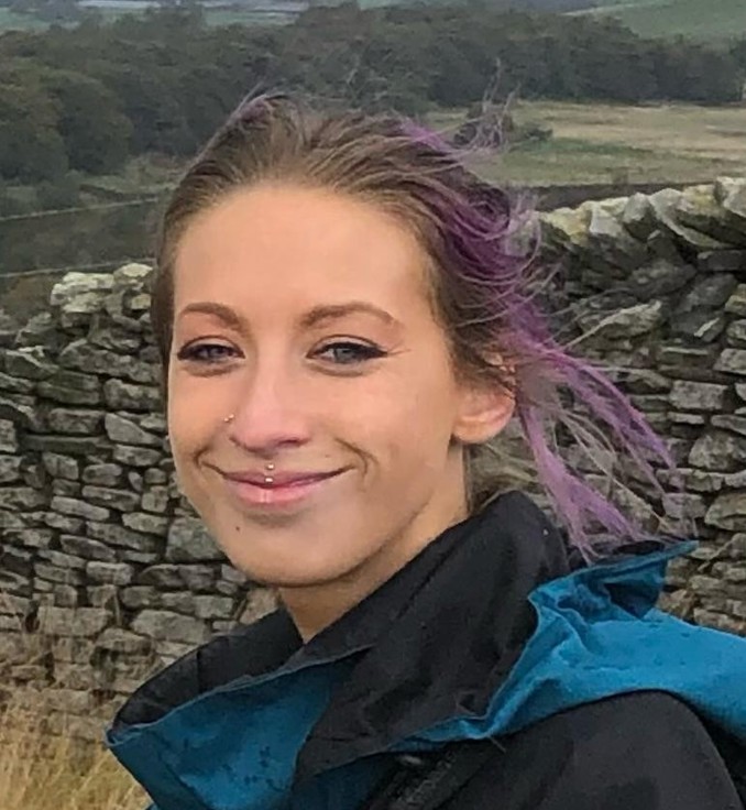 Kristie Hunt, a smiling woman with purple hair out on a walk