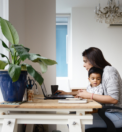 Woman working from a home office desk with her son 598878506
