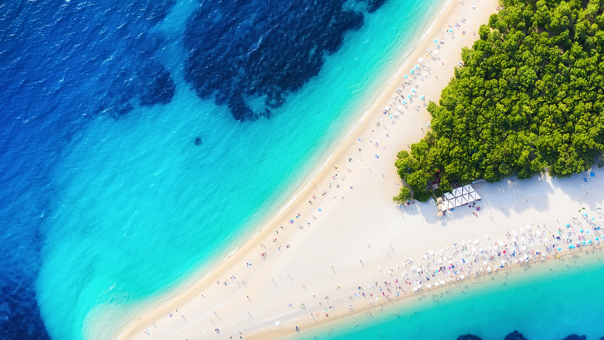Aerial view of Brač, Croatia, showing a white pebble spit extending into crystal-clear turquoise and deep blue Adriatic water