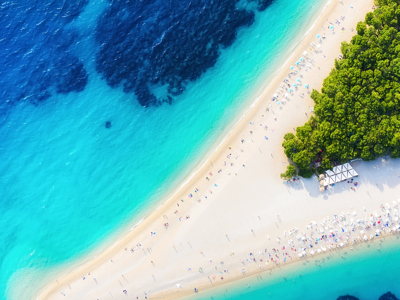 Aerial view of Brač, Croatia, showing a white pebble spit extending into crystal-clear turquoise and deep blue Adriatic water