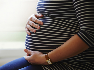 Heavily pregnant woman holding her bump