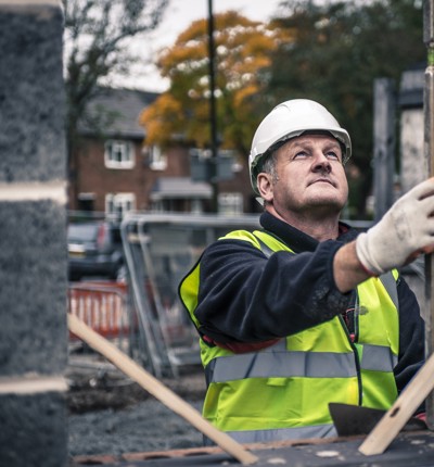 Man with helmet in construction gear building a wall