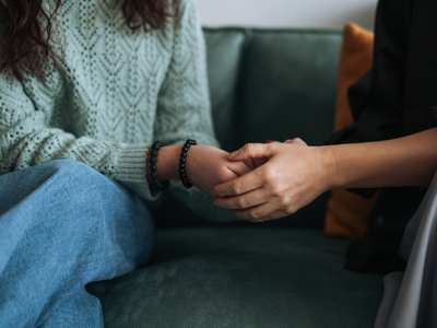 2 women holding hands showing compassion and support towards each other