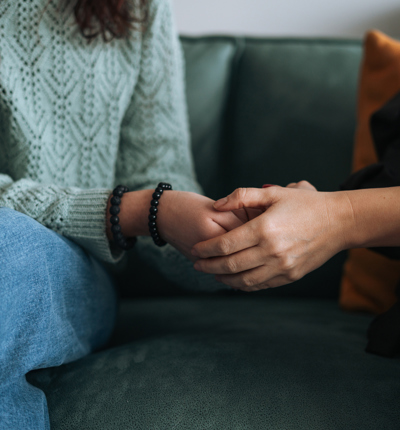 2 women holding hands showing compassion and support towards each other