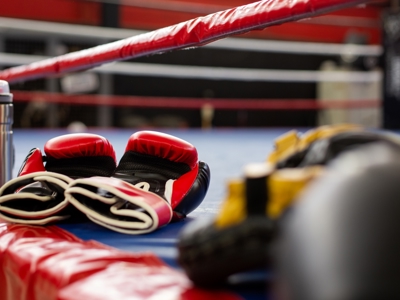 Close up of red boxing gloves on the floor of a boxing ring.